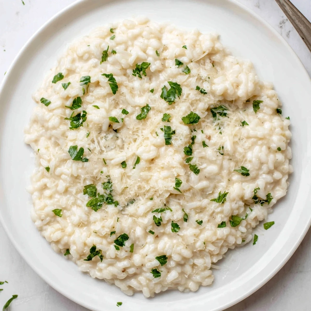 Homemade creamy rice dish, with a sprinkle of fresh parsley, offering a delightful texture and taste.