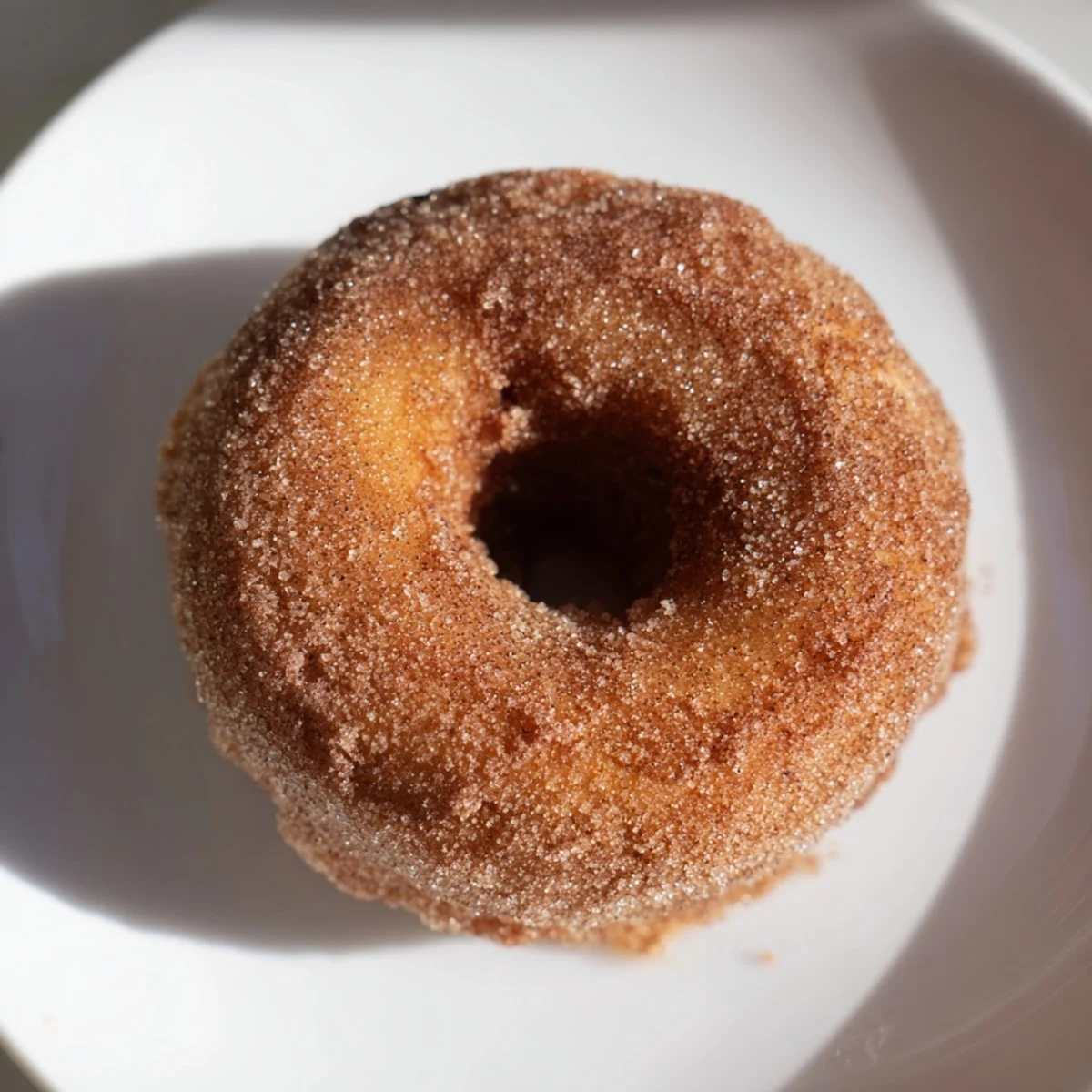Warm, golden Spiced Apple Cider Donuts, coated in cinnamon sugar, perfect for a fall treat.