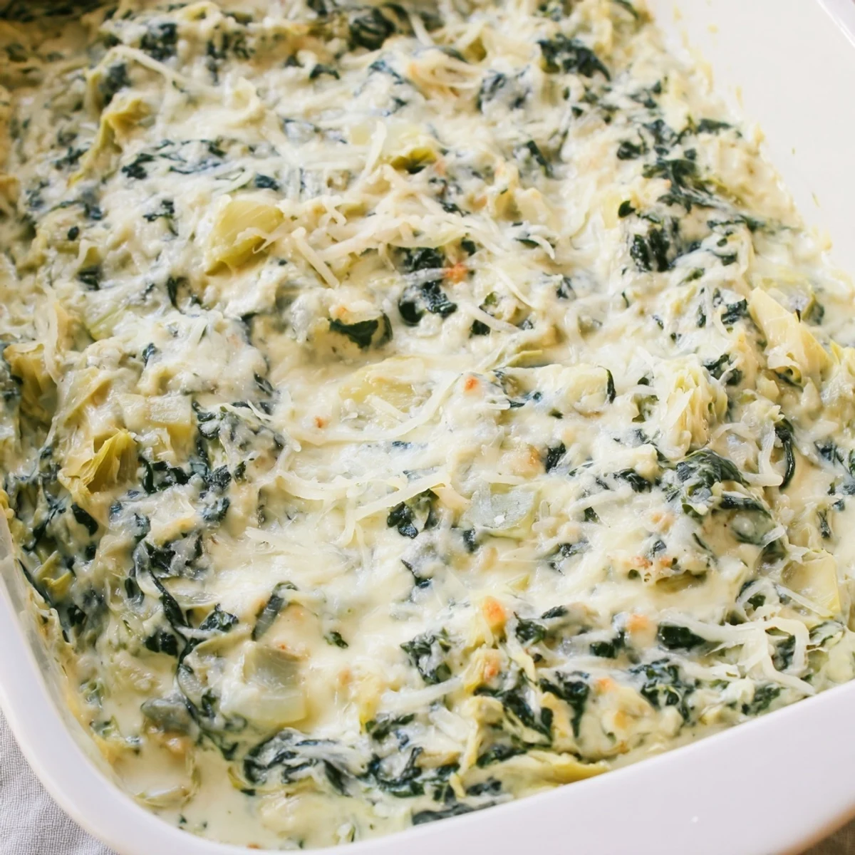 Steaming hot Creamy Spinach and Artichoke Dip, bubbling with melted cheese, served with crispy tortilla chips.