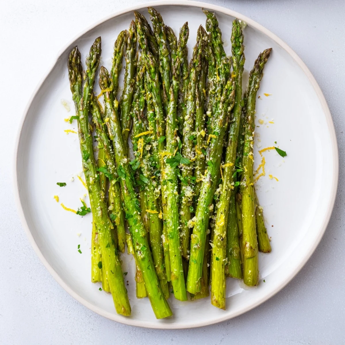 The vibrant green of cooked roasted asparagus, seasoned and ready for topping with cheese.