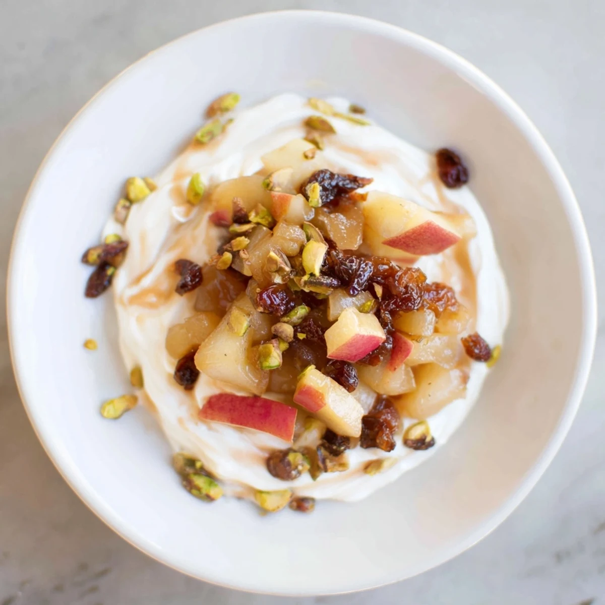 Sweet and spiced Winter Fruit Compote, drizzled over yogurt and sprinkled with nuts.