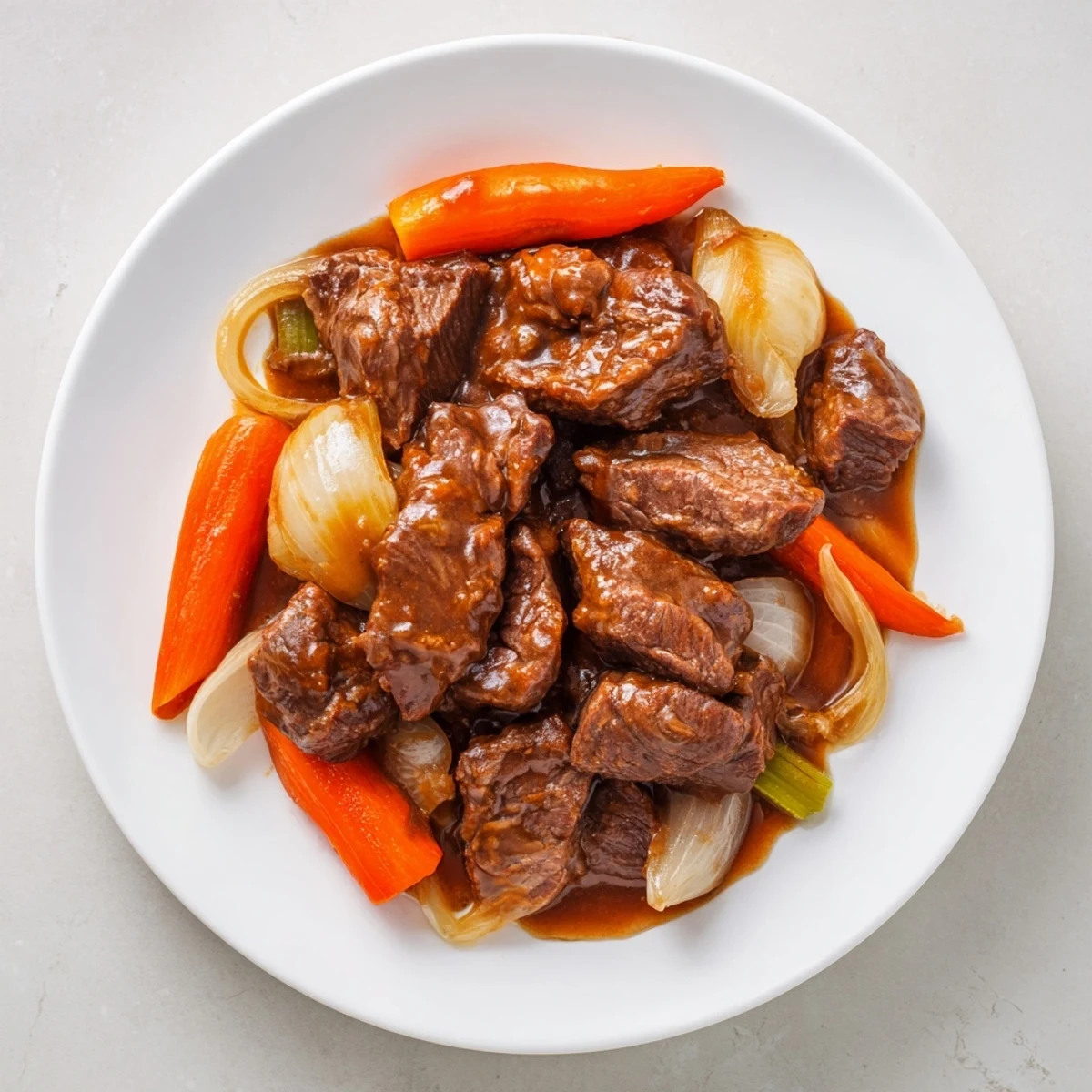 Braised Steak glistening with a rich, dark gravy and tender vegetables, a hearty home-cooked meal.