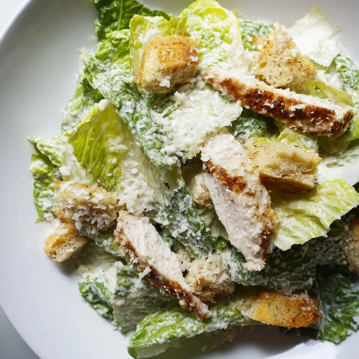 Served in a rustic bowl, this hearty Chicken Caesar Salad features crunchy garlic croutons and is ready for a satisfying meal.