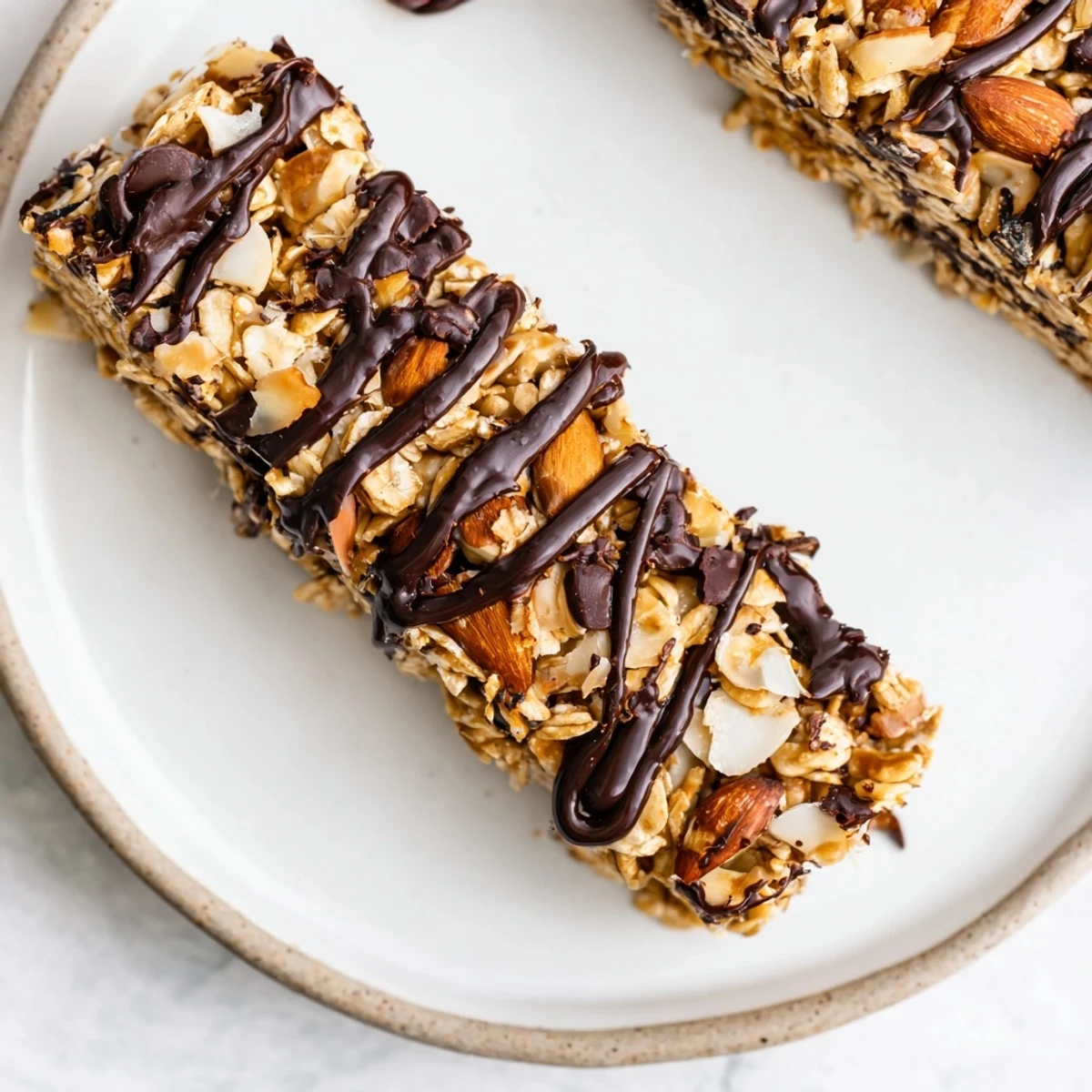 Fudgy Chocolate Snack Bars cut into squares, showcasing oats and coconut with a rich chocolate topping.