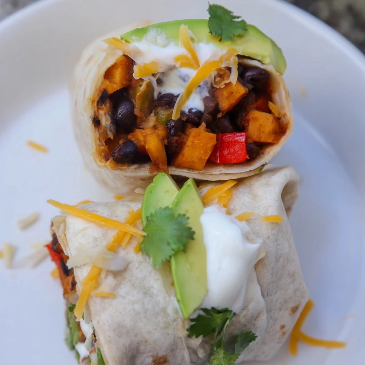 Warm Roasted Sweet Potato and Black Bean Burritos filled with seasoned vegetables and fresh cilantro.