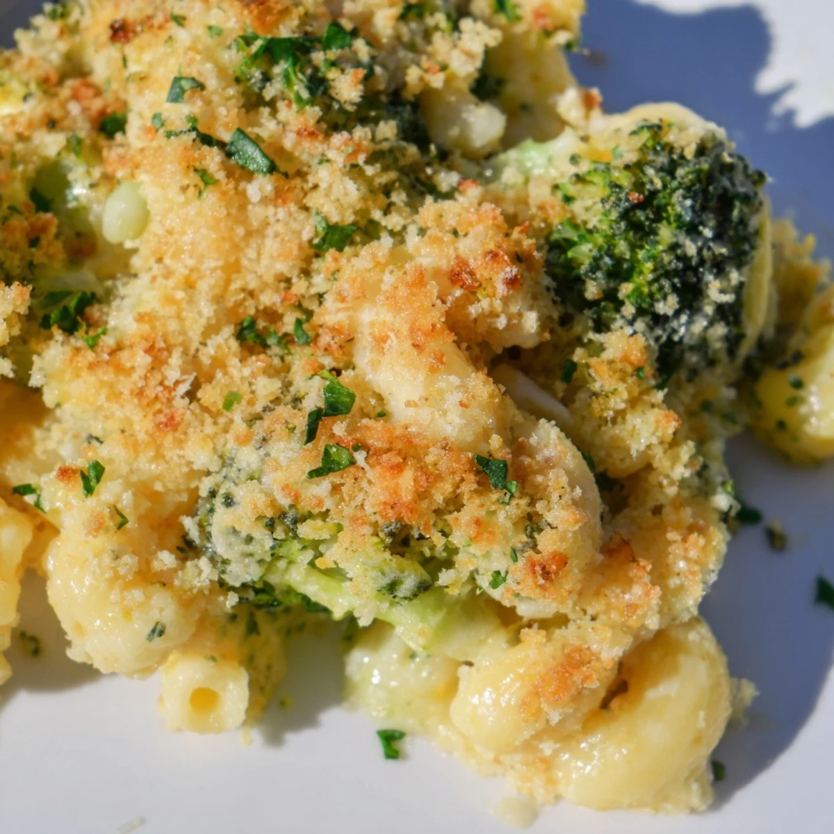 A close-up of golden Baked Macaroni and Cheese with Broccoli reveals a cheesy pull, ready to be served as a comforting main dish.