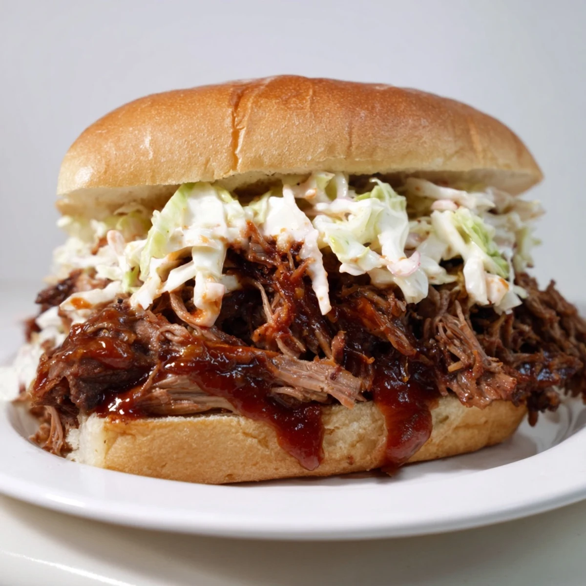Slow Cooker Pulled Beef Sandwiches piled high with tender shredded meat on a soft toasted bun, ready to serve.