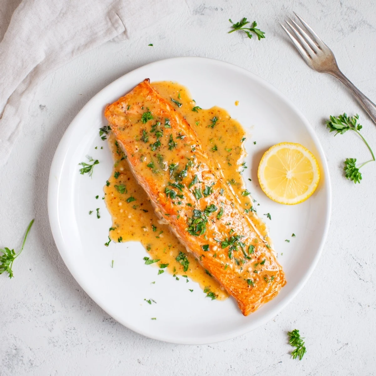 Golden-brown baked salmon fillets coated in sticky honey mustard glaze, paired with vibrant lemon wedges and fresh parsley.