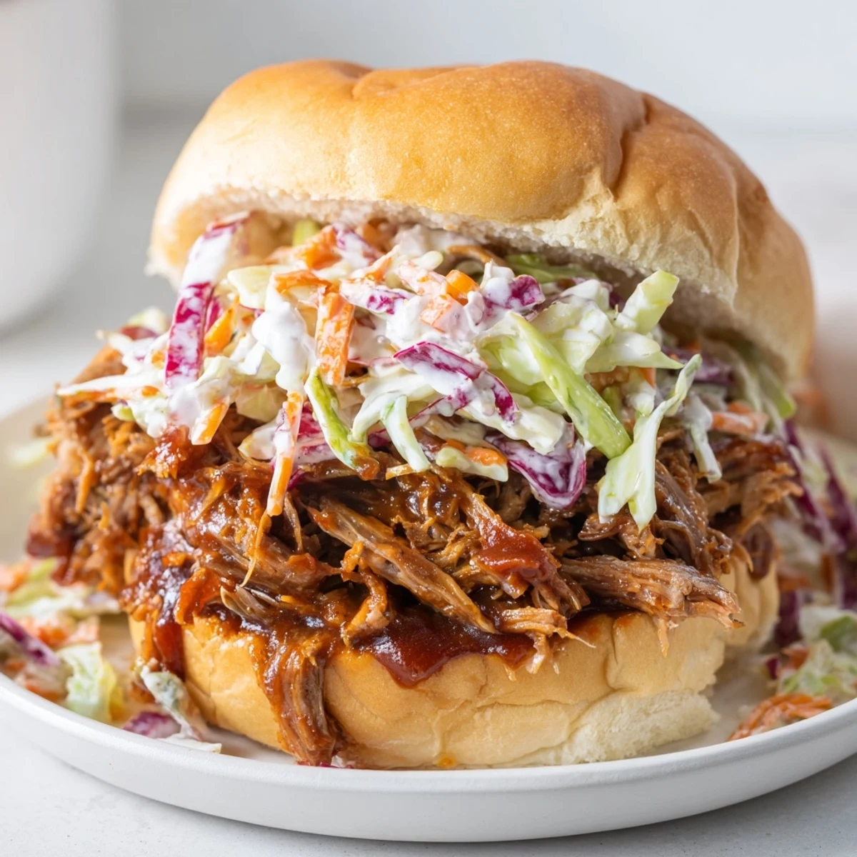 Golden-brown shredded beef, simmered with spices and barbecue sauce, piled high on a soft brioche bun.