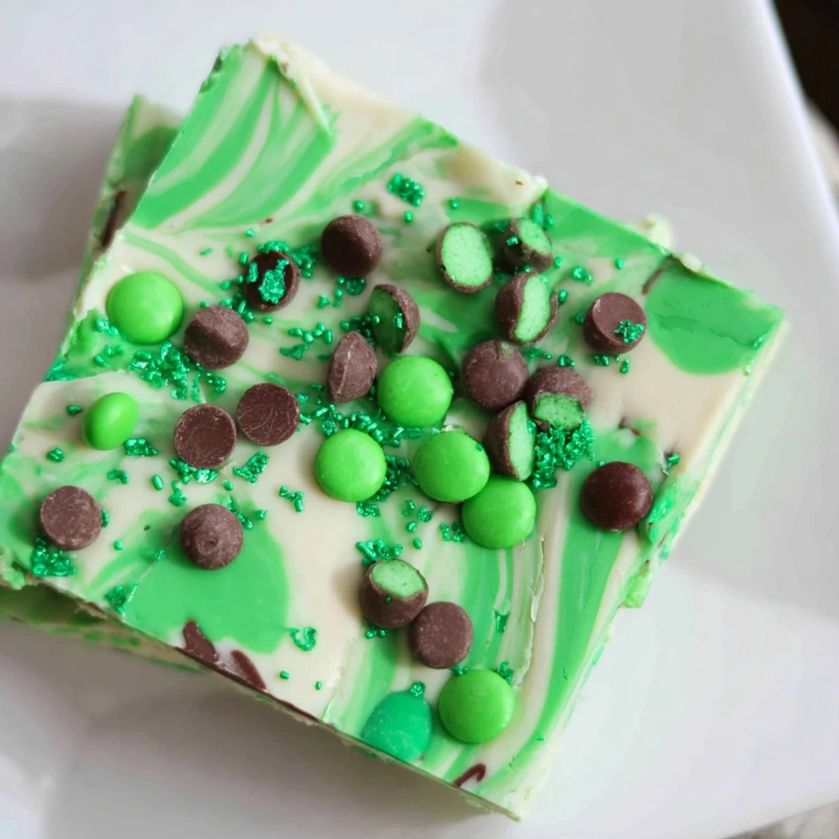 Close-up of St. Patrick's Day Mint Chocolate Bark with green M&Ms and sprinkles on a marble board. 