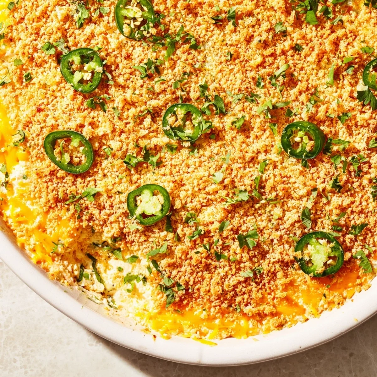 Creamy Super Bowl Jalapeño Popper Dip garnished with fresh parsley, paired alongside colorful tortilla chips on a game day table.