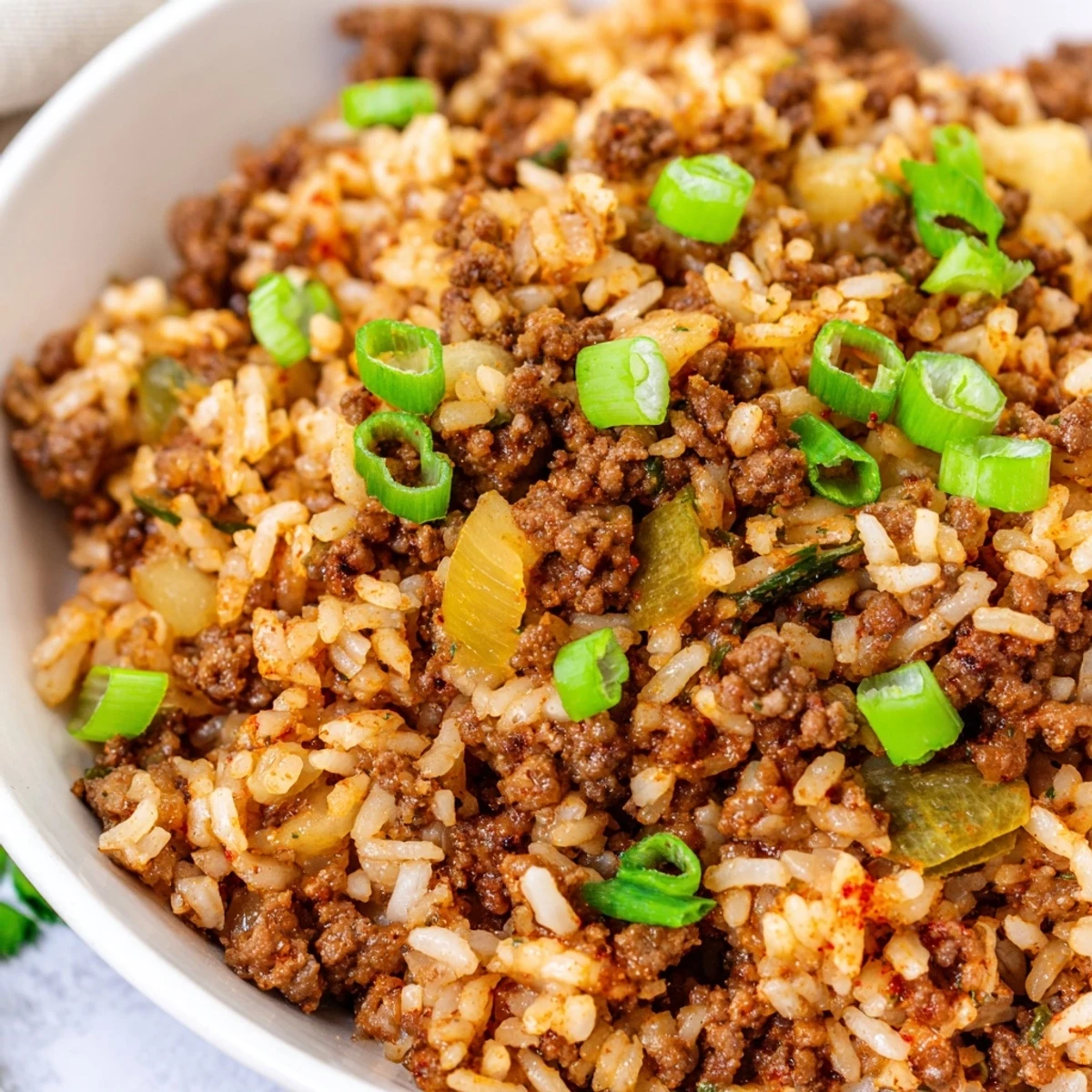 Homemade Cajun Dirty Rice with Ground Beef served alongside cornbread, showcasing a hearty Southern meal perfect for weeknights.