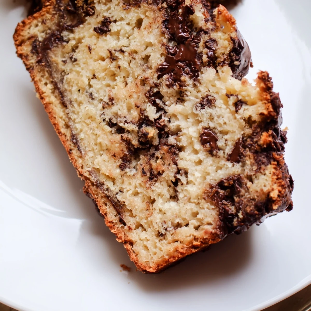 Homemade Chocolate Chip Banana Bread cooling on a wire rack, with golden-brown crust and banana aroma, ideal for sharing with family and friends.
