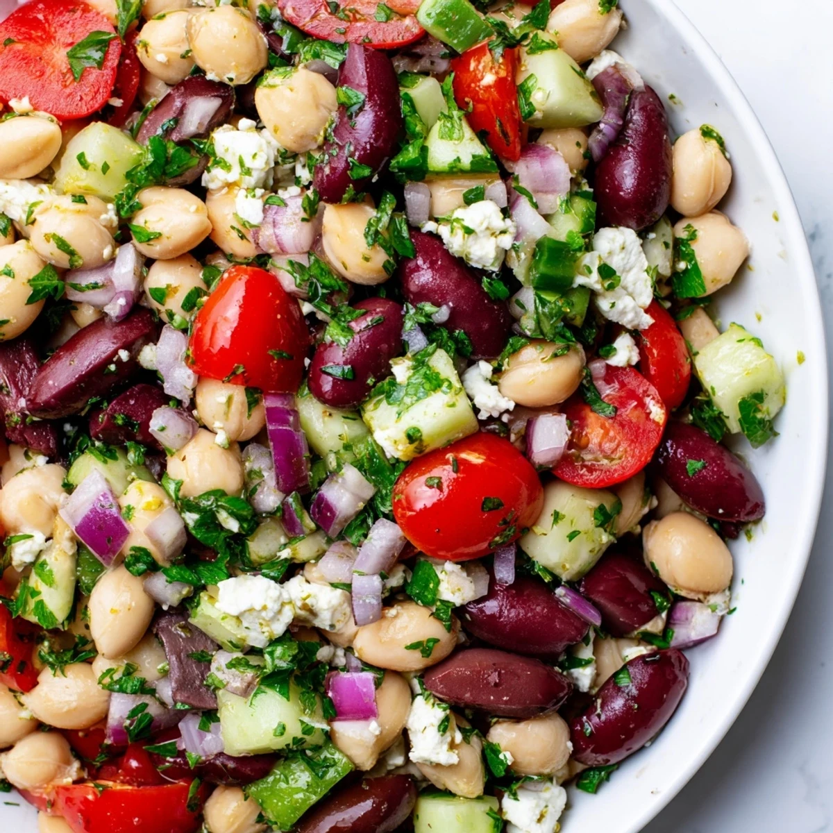 A vibrant Mediterranean Dense Bean Salad with chickpeas, cucumbers, and feta on a rustic table.