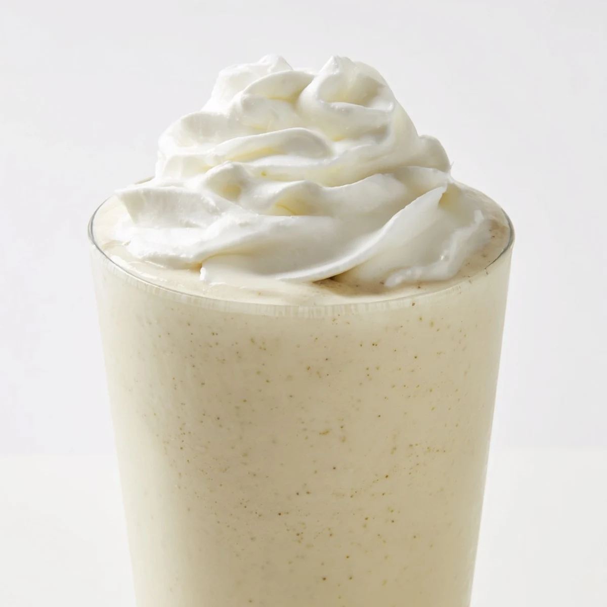 Creamy Starbucks Vanilla Bean Frappuccino topped with fluffy whipped cream in a tall glass.