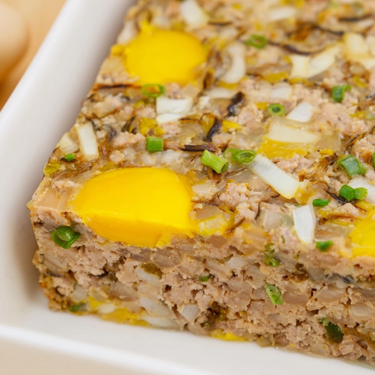 Steamed Cha Trung Hap meatloaf with golden egg topping, sliced beside fluffy jasmine rice and pickled vegetables on a plate.