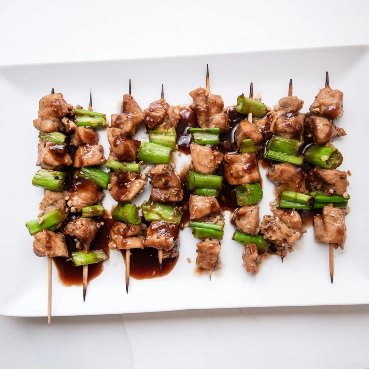 Sizzling Japanese Chicken Yakitori skewers glazed with tare sauce, served hot off the grill.