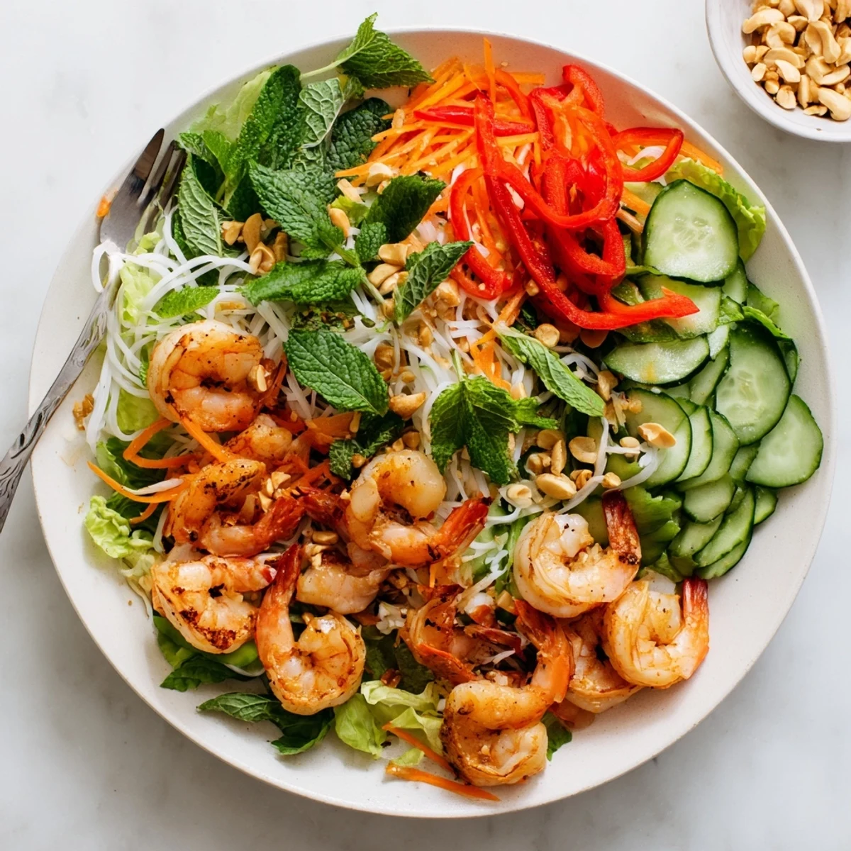 Vibrant deconstructed spring roll salad with rice noodles, herbs, shrimp, and spicy ginger sesame dressing