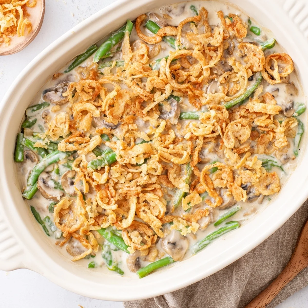 Holiday green bean casserole with fresh green beans, creamy mushroom base, and golden brown crushed Ritz cracker crust