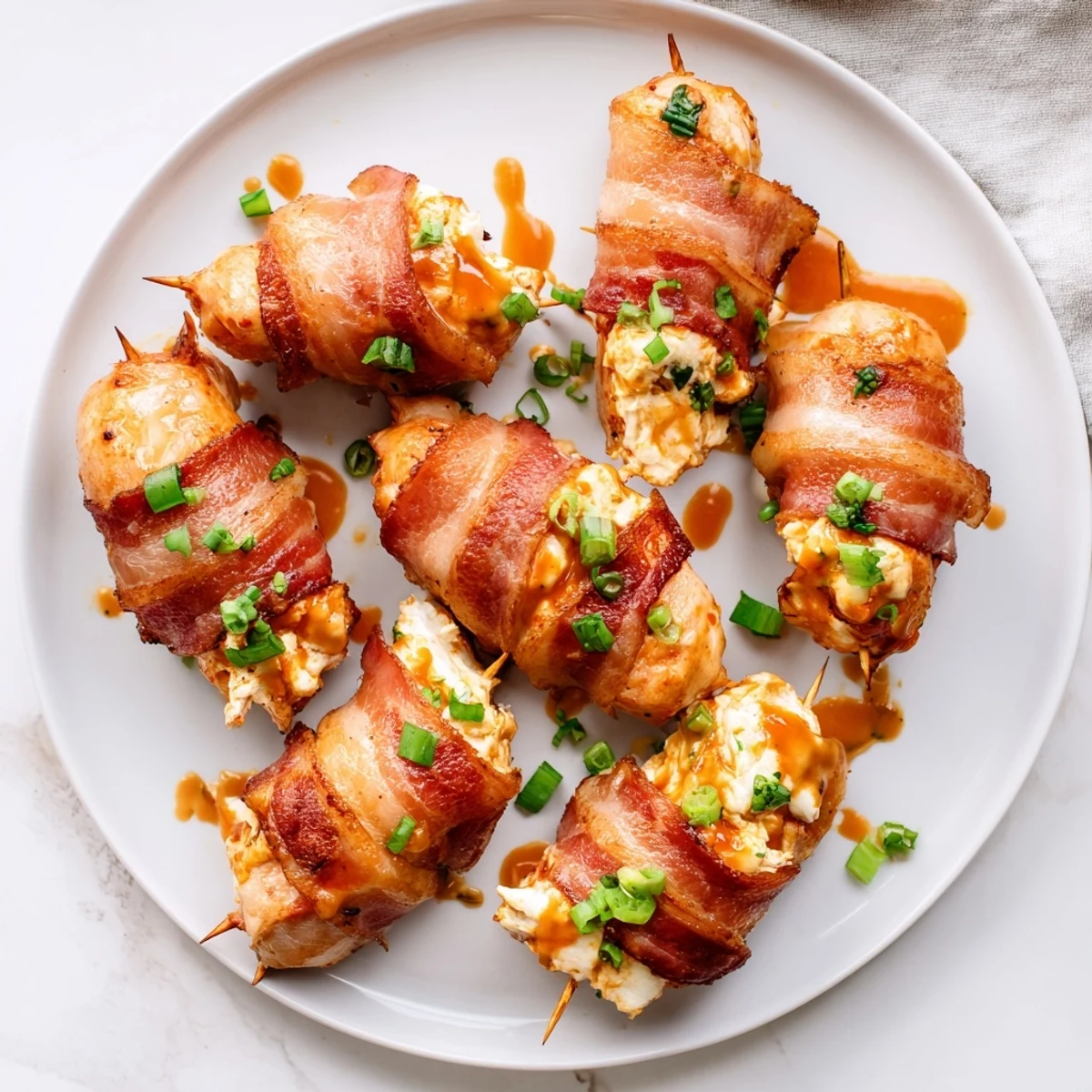 Golden brown Buffalo chicken bombs stuffed with cream cheese and mozzarella, garnished with fresh chives