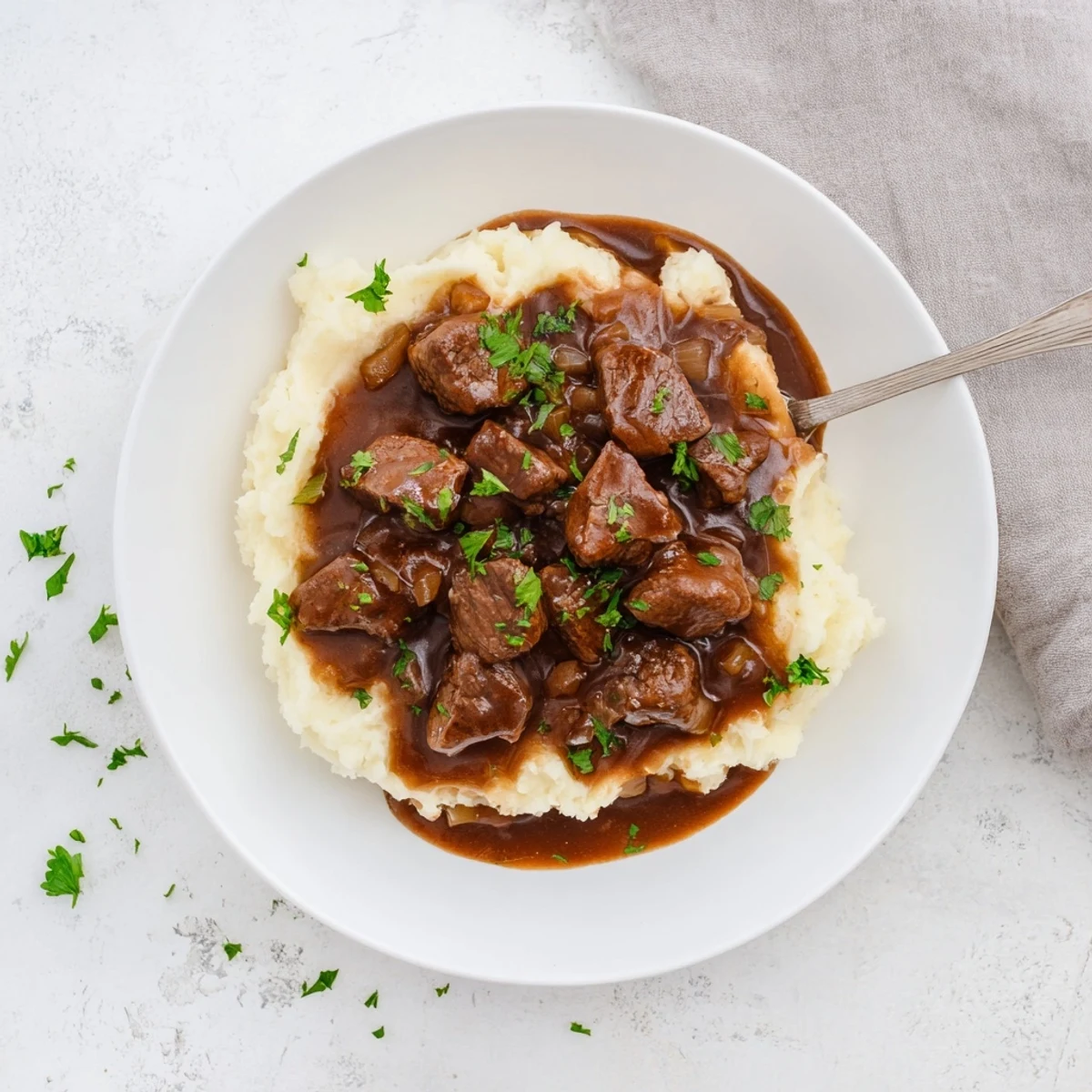 Golden brown slow cooker beef tips and gravy served over fluffy mashed potatoes