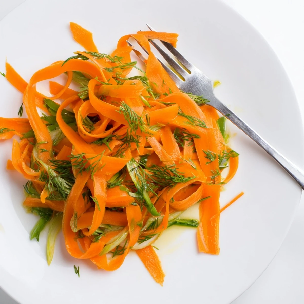 Crisp marinated carrot salad glistening with lemon dill dressing in a serving bowl