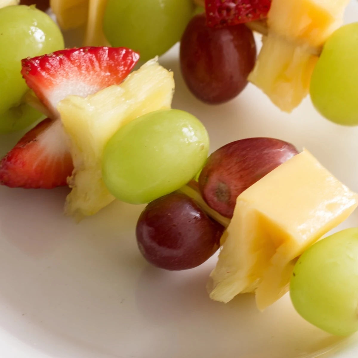 Fresh fruit and cheese kabobs featuring ripe pineapple grapes and creamy Monterey Jack skewers
