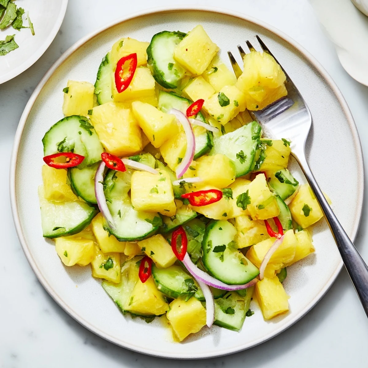 Bowl of Pineapple Cucumber Salad with zesty lime dressing and cilantro