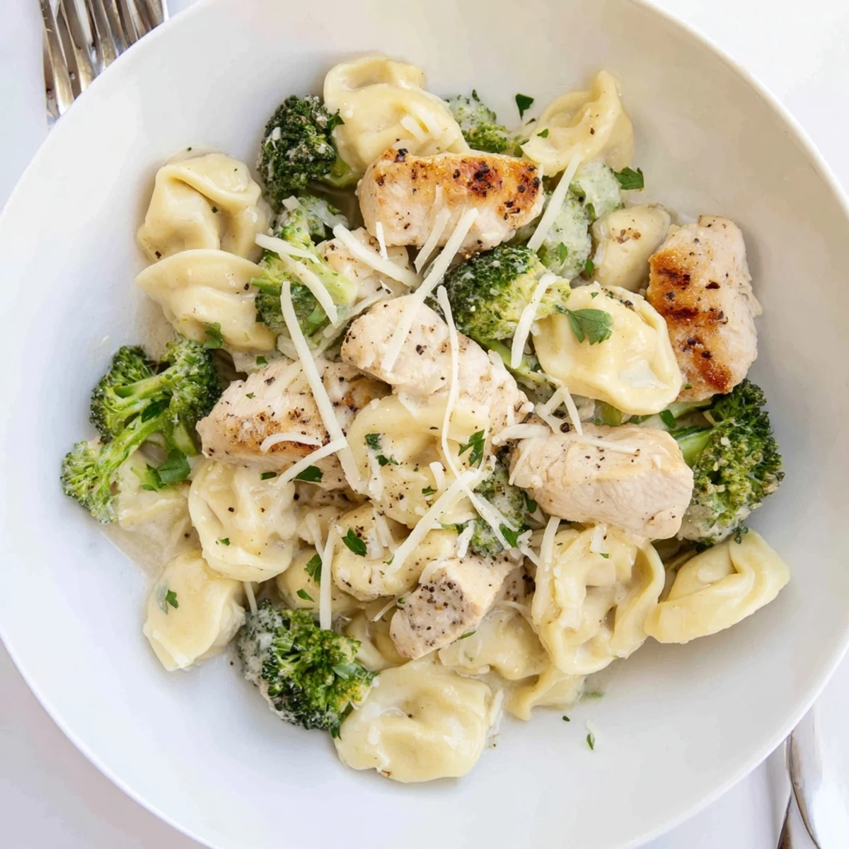 Creamy Garlic Parmesan Tortellini Chicken Broccoli Recipe with seared chicken and crisp broccoli, parsley.