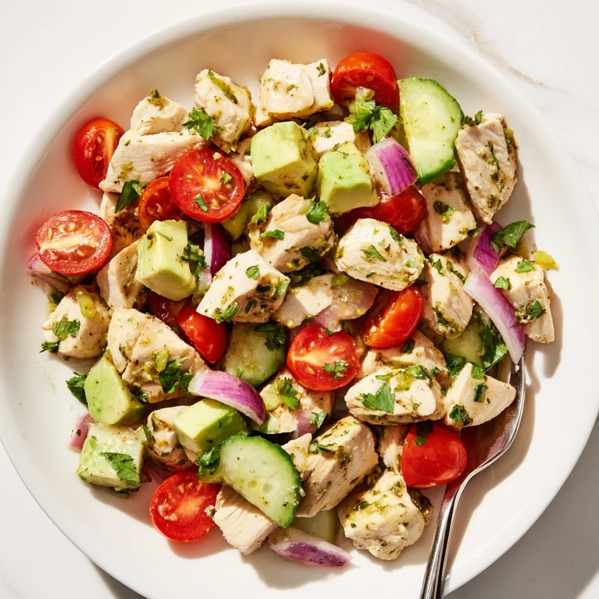 Colorful plate of healthy avocado chicken salad featuring crisp vegetables and juicy chicken in tangy lime dressing