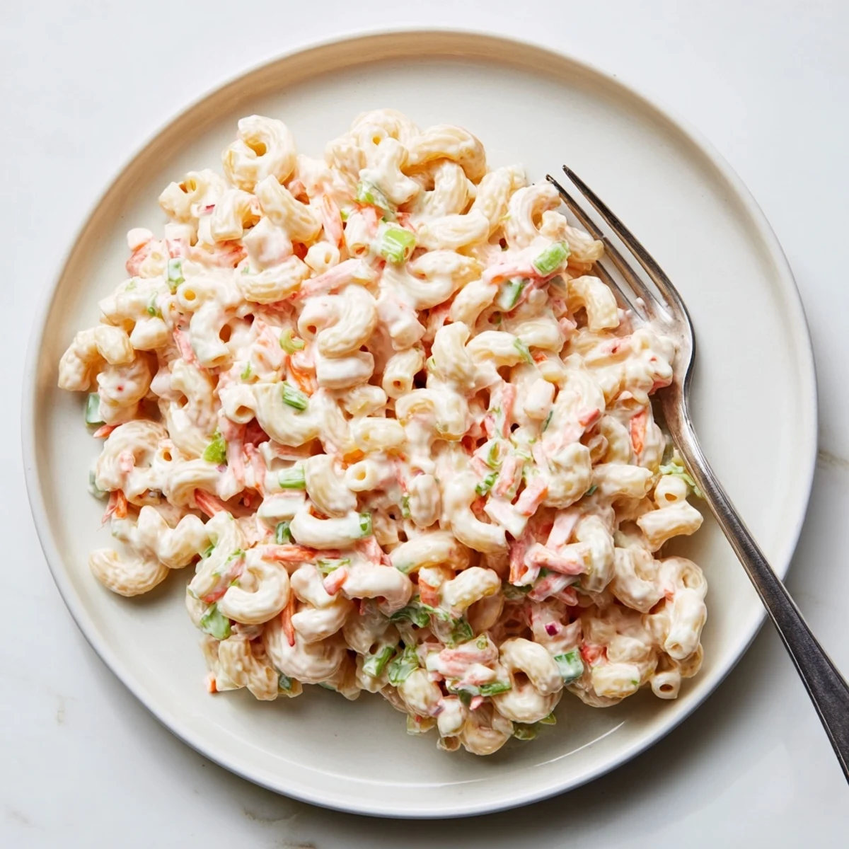 Traditional Hawaiian style mac salad featuring soft pasta in a rich creamy sauce with green onion garnish