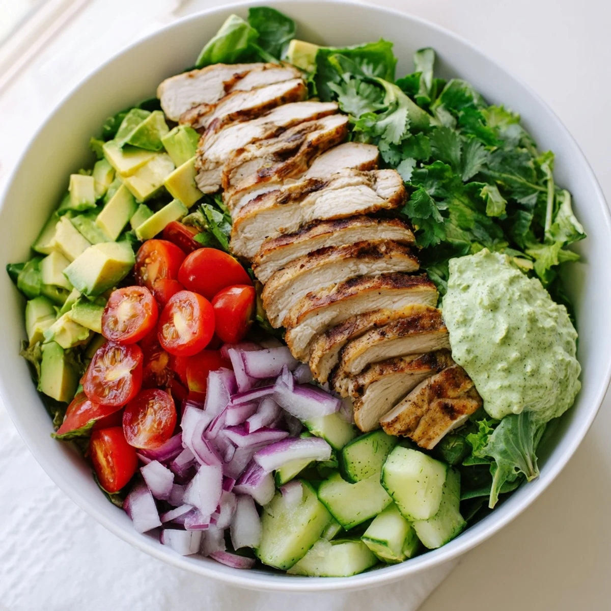 Golden sliced grilled chicken atop crisp greens with ripe avocado and zesty lime dressing