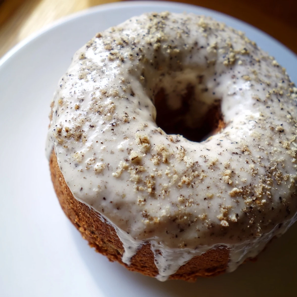 Baked banana bread donuts with sweet glaze drizzle on wire cooling rack