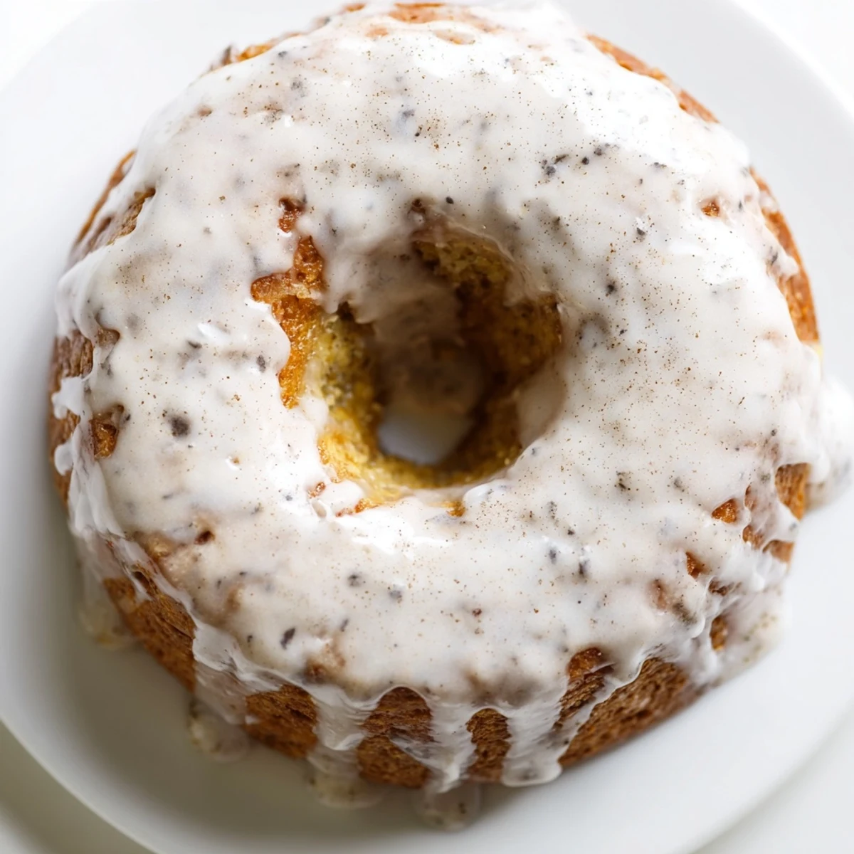 Fluffy banana bread donuts topped with cinnamon sugar glaze on white plate