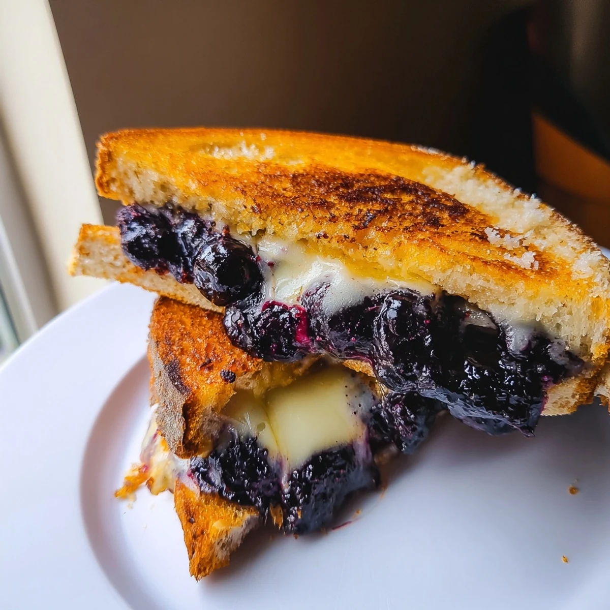 Crispy Blueberry Grilled Cheese hot from skillet, honeyed blueberries and Parmesan-crisped edges.