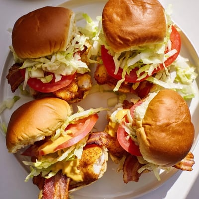 Freshly assembled Honey Mustard BLT Chicken Sliders are ready to serve on a platter, perfect for a party spread.