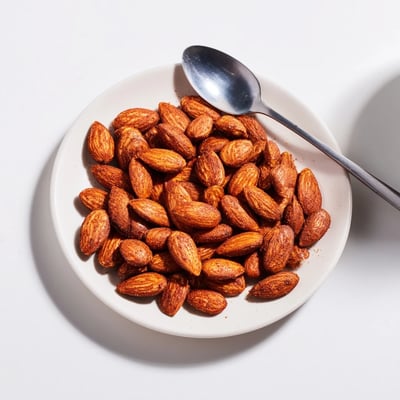 Crunchy roasted almonds glistening with sea salt on a parchment-lined baking sheet